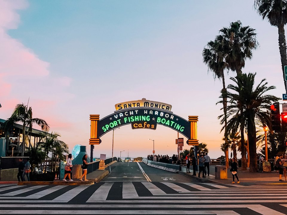 The Santa Monica Pier entrance arch at sunset